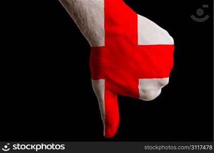 Hand with thumb down gesture in colored england national flag as symbol of negative political, cultural, social management of country