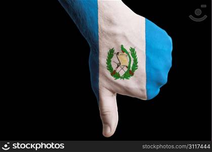 Hand with thumb down gesture in colored guatemala national flag as symbol of negative political, cultural, social management of country