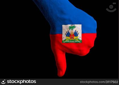 Hand with thumb down gesture in colored haiti national flag as symbol of negative political, cultural, social management of country