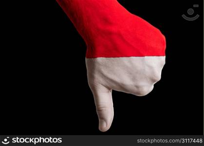 Hand with thumb down gesture in colored indonesia national flag as symbol of negative political, cultural, social management of country