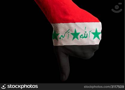 Hand with thumb down gesture in colored iraq national flag as symbol of negative political, cultural, social management of country
