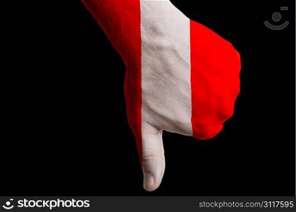 Hand with thumb down gesture in colored peru national flag as symbol of negative political, cultural, social management of country