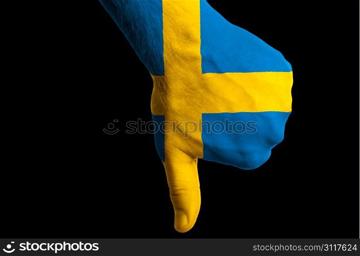 Hand with thumb down gesture in colored sweden national flag as symbol of negative political, cultural, social management of country