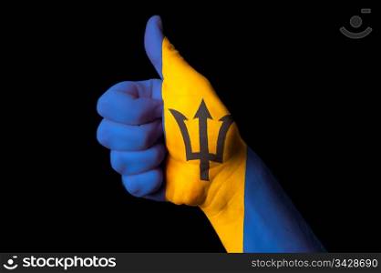 Hand with thumb up gesture in colored barbados national flag as symbol of excellence, achievement, good, - for tourism and touristic advertising, positive political, cultural, social management of country
