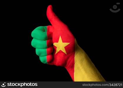 Hand with thumb up gesture in colored cameroon national flag as symbol of excellence, achievement, good, - for tourism and touristic advertising, positive political, cultural, social management of country