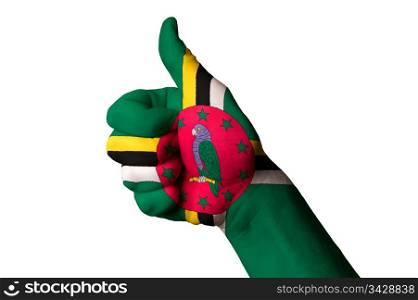 Hand with thumb up gesture in colored dominican national flag as symbol of excellence, achievement, good, - for tourism and touristic advertising, positive political, cultural, social management of country