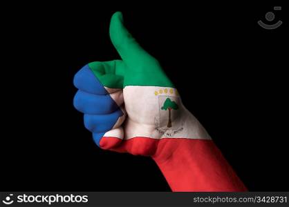 Hand with thumb up gesture in colored equatorial guinea national flag as symbol of excellence, achievement, good, - for tourism and touristic advertising, positive political, cultural, social management of country