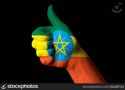 Hand with thumb up gesture in colored ethiopia national flag as symbol of excellence, achievement, good, - for tourism and touristic advertising, positive political, cultural, social management of country