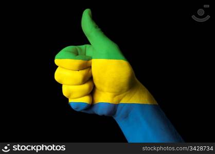 Hand with thumb up gesture in colored gabon national flag as symbol of excellence, achievement, good, - for tourism and touristic advertising, positive political, cultural, social management of country