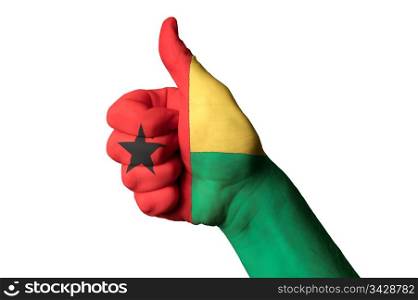 Hand with thumb up gesture in colored guinea bissau national flag as symbol of excellence, achievement, good, - for tourism and touristic advertising, positive political, cultural, social management of country