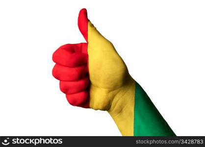 Hand with thumb up gesture in colored guinea national flag as symbol of excellence, achievement, good, - for tourism and touristic advertising, positive political, cultural, social management of country