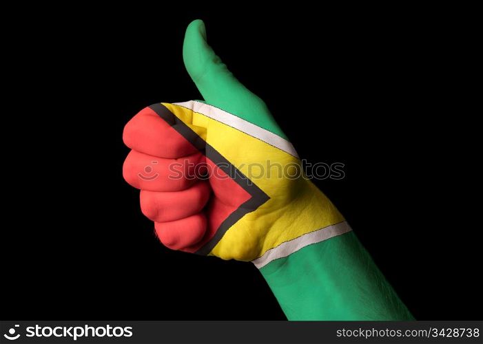 Hand with thumb up gesture in colored guyana national flag as symbol of excellence, achievement, good, - for tourism and touristic advertising, positive political, cultural, social management of country
