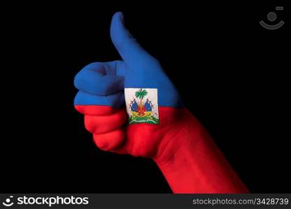 Hand with thumb up gesture in colored haiti national flag as symbol of excellence, achievement, good, - for tourism and touristic advertising, positive political, cultural, social management of country