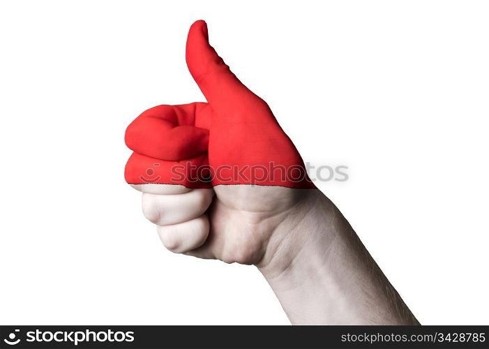 Hand with thumb up gesture in colored indonesia national flag as symbol of excellence, achievement, good, - for tourism and touristic advertising, positive political, cultural, social management of country