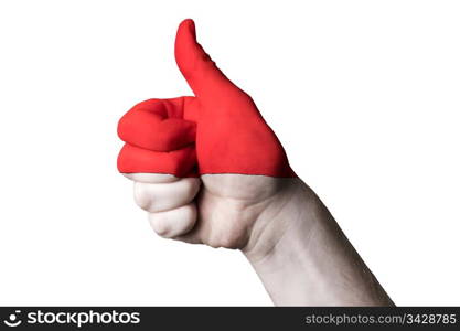 Hand with thumb up gesture in colored indonesia national flag as symbol of excellence, achievement, good, - for tourism and touristic advertising, positive political, cultural, social management of country