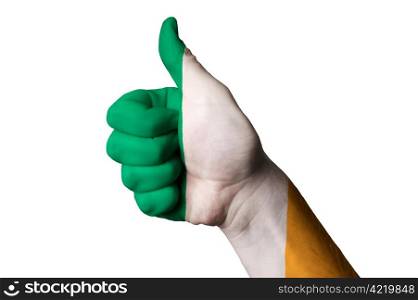 Hand with thumb up gesture in colored ireland national flag as symbol of excellence, achievement, good, - useful for tourism and touristic advertising and also current positive political, cultural, social management of state or country