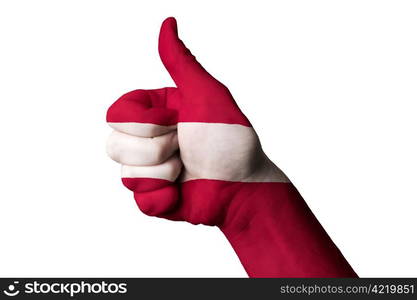 Hand with thumb up gesture in colored latvia national flag as symbol of excellence, achievement, good, - useful for tourism and touristic advertising and also current positive political, cultural, social management of state or country