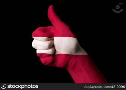 Hand with thumb up gesture in colored latvia national flag as symbol of excellence, achievement, good, - useful for tourism and touristic advertising and also current positive political, cultural, social management of state or country