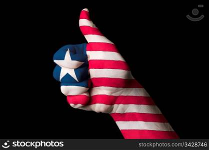Hand with thumb up gesture in colored liberia national flag as symbol of excellence, achievement, good, - for tourism and touristic advertising, positive political, cultural, social management of country