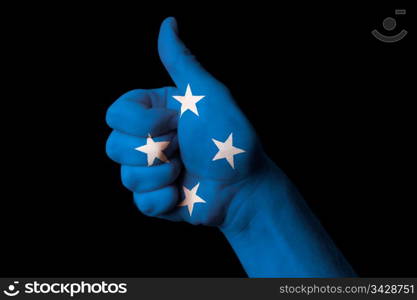 Hand with thumb up gesture in colored micronesia national flag as symbol of excellence, achievement, good, - for tourism and touristic advertising, positive political, cultural, social management of country