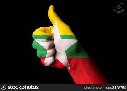 Hand with thumb up gesture in colored myanmar national flag as symbol of excellence, achievement, good, - for tourism and touristic advertising, positive political, cultural, social management of country