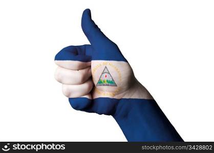 Hand with thumb up gesture in colored nicaragua national flag as symbol of excellence, achievement, good, - for tourism and touristic advertising, positive political, cultural, social management of country