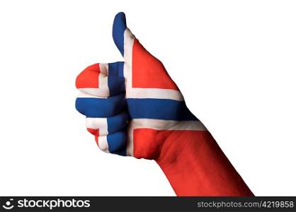 Hand with thumb up gesture in colored norway national flag as symbol of excellence, achievement, good, - useful for tourism and touristic advertising and also current positive political, cultural, social management of state or country
