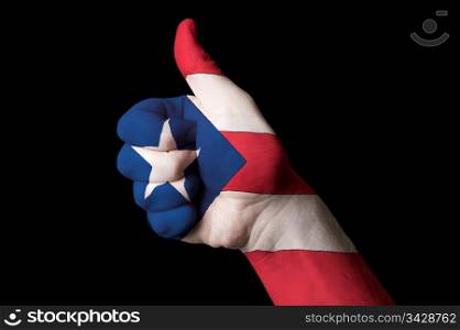 Hand with thumb up gesture in colored puertorico national flag as symbol of excellence, achievement, good, - for tourism and touristic advertising, positive political, cultural, social management of country