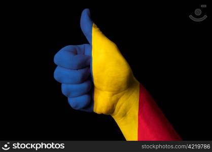 Hand with thumb up gesture in colored romania national flag as symbol of excellence, achievement, good, - useful for tourism and touristic advertising and also current positive political, cultural, social management of state or country