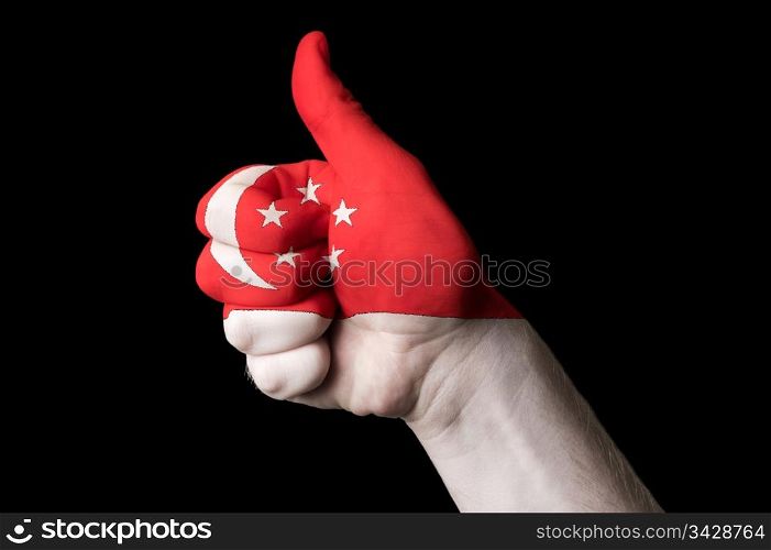 Hand with thumb up gesture in colored singapore national flag as symbol of excellence, achievement, good, - for tourism and touristic advertising, positive political, cultural, social management of country