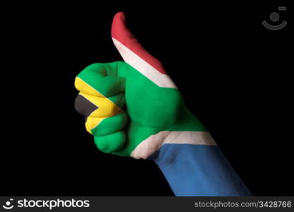 Hand with thumb up gesture in colored south africa national flag as symbol of excellence, achievement, good, - for tourism and touristic advertising, positive political, cultural, social management of country