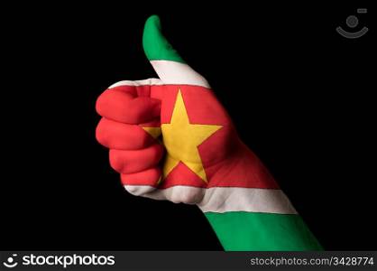 Hand with thumb up gesture in colored surinam national flag as symbol of excellence, achievement, good, - for tourism and touristic advertising, positive political, cultural, social management of country
