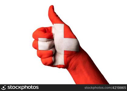 Hand with thumb up gesture in colored swiss national flag as symbol of excellence, achievement, good, - useful for tourism and touristic advertising and also current positive political, cultural, social management of state or country