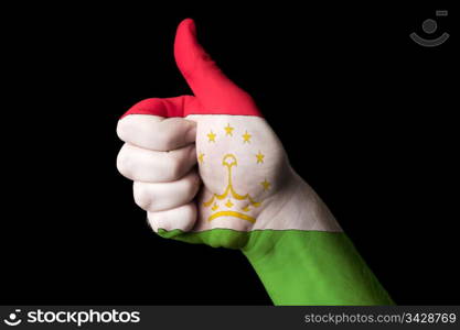 Hand with thumb up gesture in colored tajikistan national flag as symbol of excellence, achievement, good, - for tourism and touristic advertising, positive political, cultural, social management of country