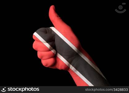 Hand with thumb up gesture in colored trinidad tobago national flag as symbol of excellence, achievement, good, - for tourism and touristic advertising, positive political, cultural, social management of country