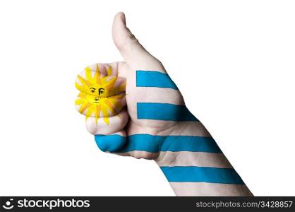 Hand with thumb up gesture in colored uruguay national flag as symbol of excellence, achievement, good, - for tourism and touristic advertising, positive political, cultural, social management of country