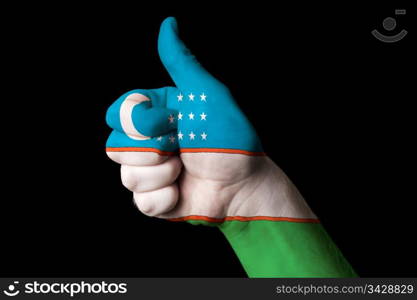 Hand with thumb up gesture in colored uzbekistan national flag as symbol of excellence, achievement, good, - for tourism and touristic advertising, positive political, cultural, social management of country