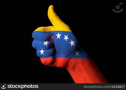Hand with thumb up gesture in colored venezuela national flag as symbol of excellence, achievement, good, - for tourism and touristic advertising, positive political, cultural, social management of country