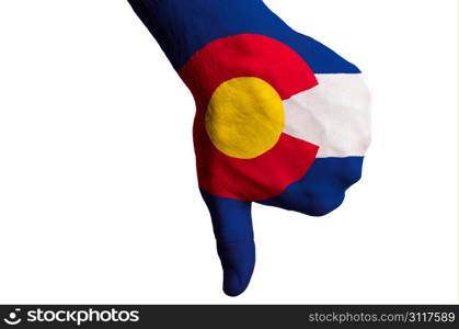 Hand with thumbs down gesture in colored american state of colorado flag as symbol of negative political, cultural, social management of state