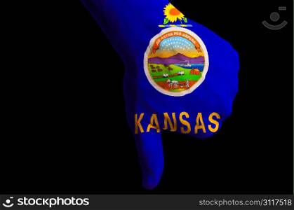 Hand with thumbs down gesture in colored american state of kansas flag as symbol of negative political, cultural, social management of country