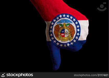 Hand with thumbs down gesture in colored american state of missouri flag as symbol of negative political, cultural, social management of state