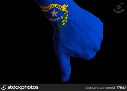 Hand with thumbs down gesture in colored american state of new hampshire flag as symbol of negative political, cultural, social management of state