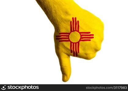 Hand with thumbs down gesture in colored american state of new mexico flag as symbol of negative political, cultural, social management of state