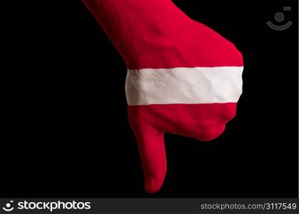 Hand with thumbs down gesture in colored latvia national flag as symbol of negative political, cultural, social management of country