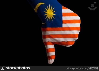 Hand with thumbs down gesture in colored malaysia national flag as symbol of negative political, cultural, social management of country