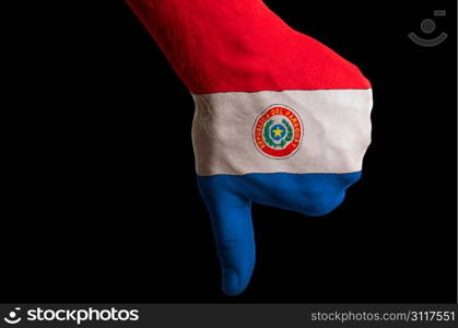 Hand with thumbs down gesture in colored paraguay national flag as symbol of negative political, cultural, social management of country