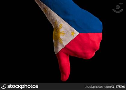 Hand with thumbs down gesture in colored philippines national flag as symbol of negative political, cultural, social management of country