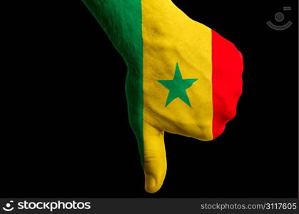 Hand with thumbs down gesture in colored senegal national flag as symbol of negative political, cultural, social management of country