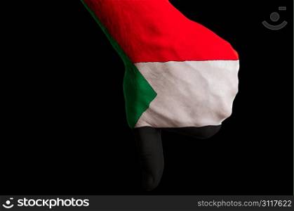Hand with thumbs down gesture in colored sudan national flag as symbol of negative political, cultural, social management of country