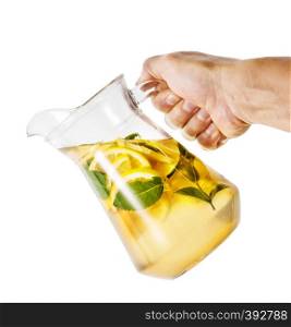 Hand with tilted jug of homemade lemonade isolated on white background. Hand with tilted jug of homemade lemonade